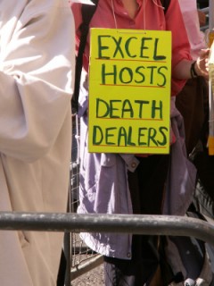 Placard reading "Excel Hosts Death Dealers"