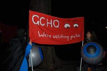 giant eyeballs amd a banner promising to watch gchq